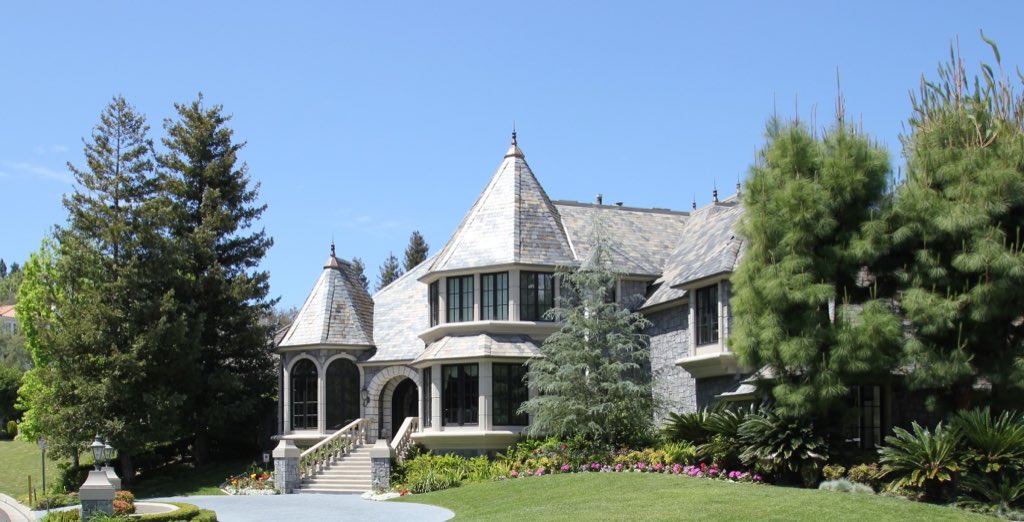 Stone chateau: turret and slate roofline among the trees